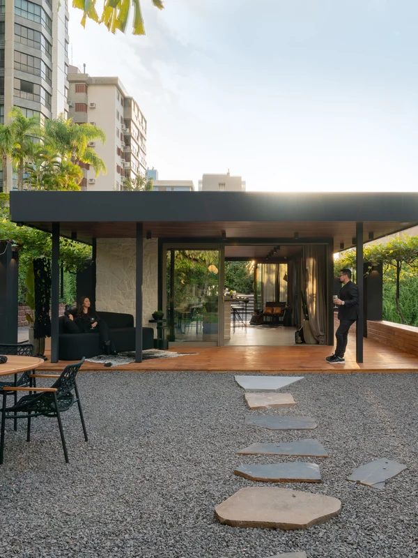 Projeto arquitetônico com lareira ecológica Loft Round Somer em jardim urbano, estrutura metálica e deck de madeira