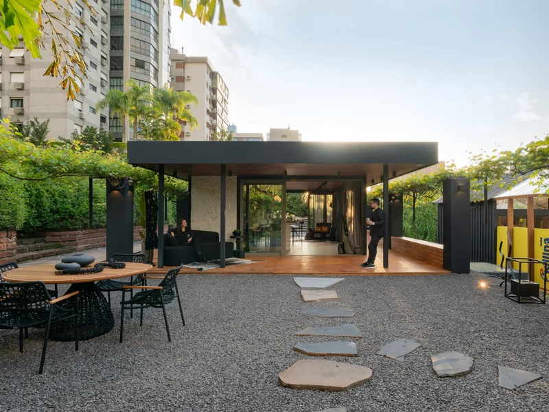 Lareira Loft Round 2000G LSLR-2000G-AP da Somer em deck residencial integrado a área de jardim e refeitório externo com mesa redonda e poltronas.