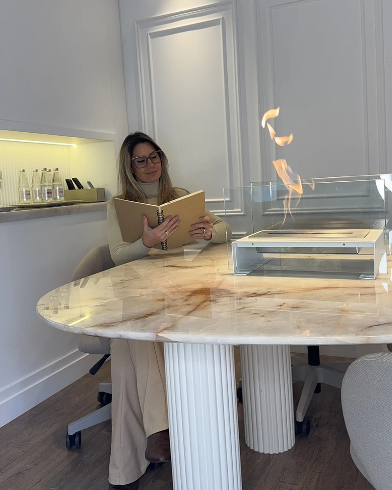 Lareira ecológica GO! Branca Somer com chama viva sobre mesa em ambiente interno de apartamento de alto padrão